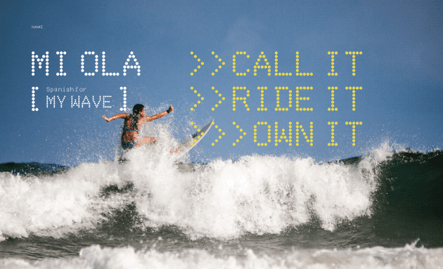 A surfer riding the waves in front of a message board.